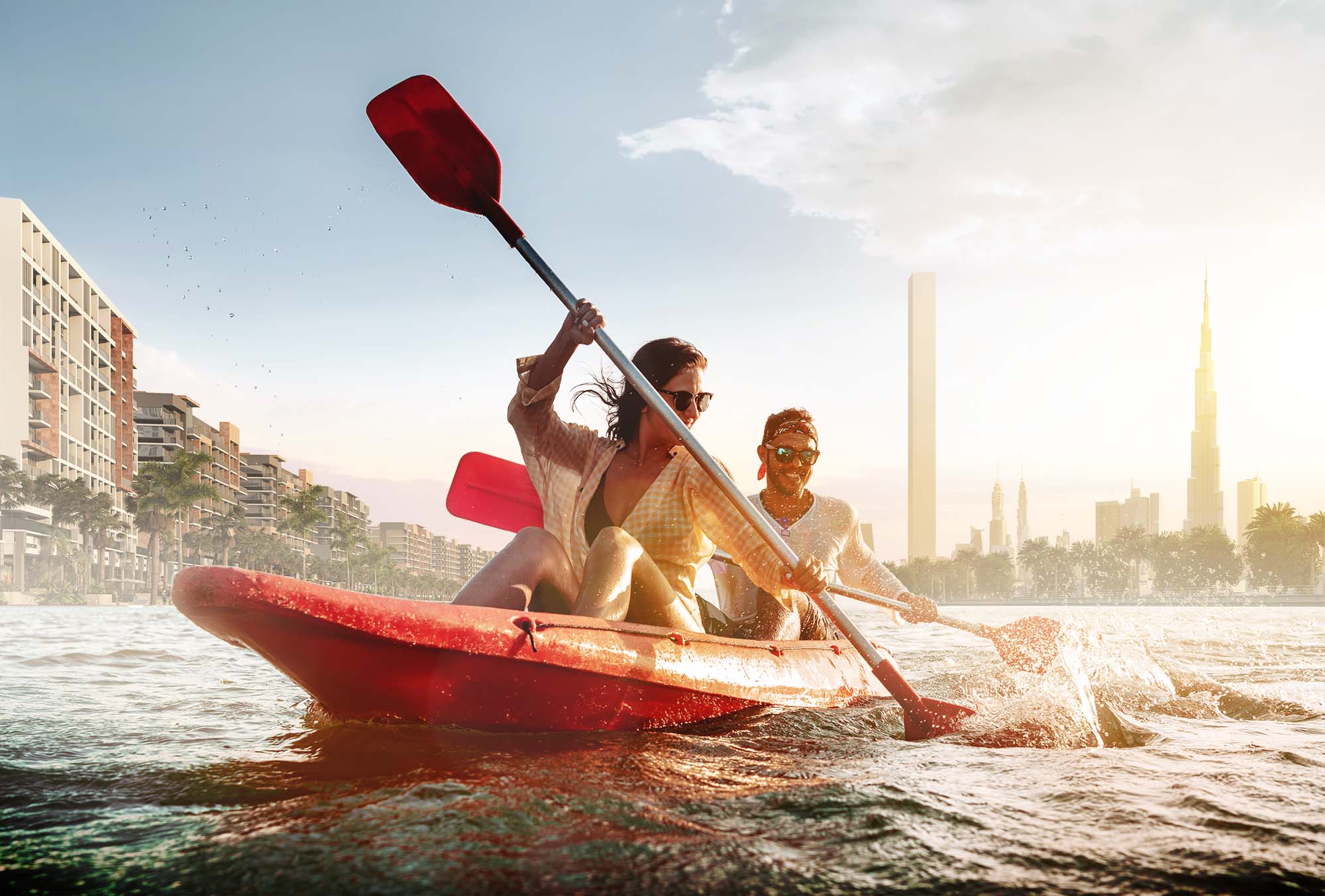 Couple kayaking on the lagoon at Azizi Riviera with Dubai skyline in background